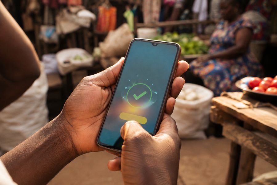 Hands confirming a Mobile Money payment on a phone
