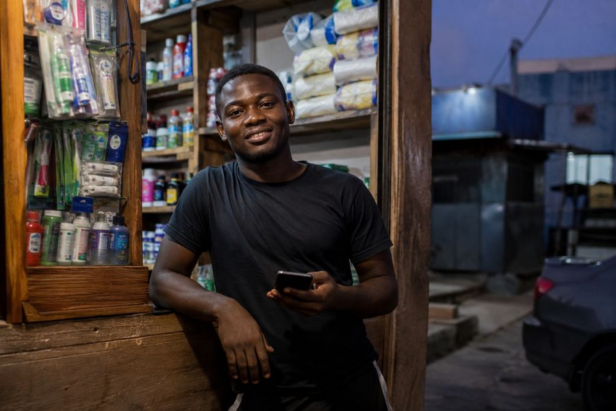 Shop owner checking his phone at his store